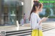 A woman in a yellow skirt is looking at her phone.