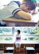 A woman in a school uniform sitting at a desk.