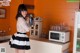 A woman standing in a kitchen holding a coffee pot.