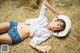 A woman laying on top of a pile of hay.