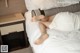A woman laying on a bed with her feet up on a pillow.