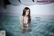 A woman in a blue bikini standing in a pool.
